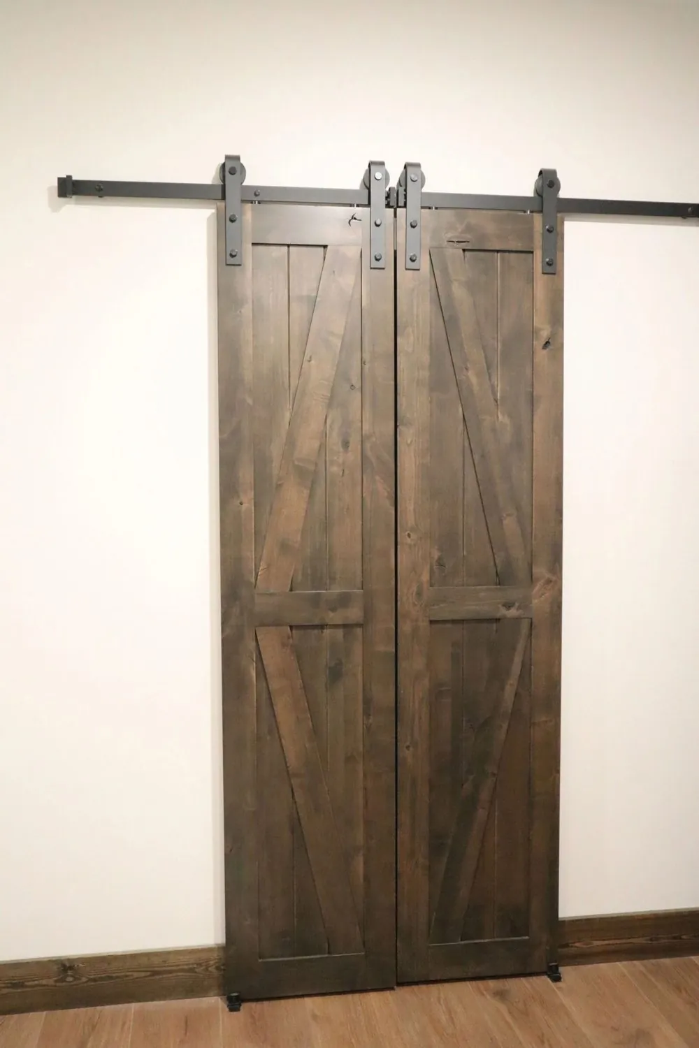 Custom sliding barn door in stained hardwood on black track hardware