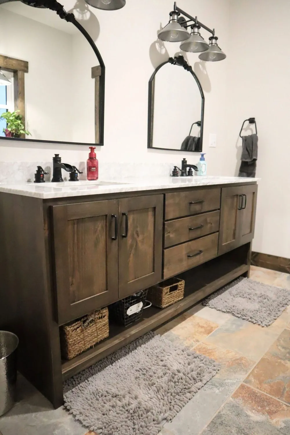 Custom double bathroom vanity in stained hardwood with soft-close drawers and open basket storage